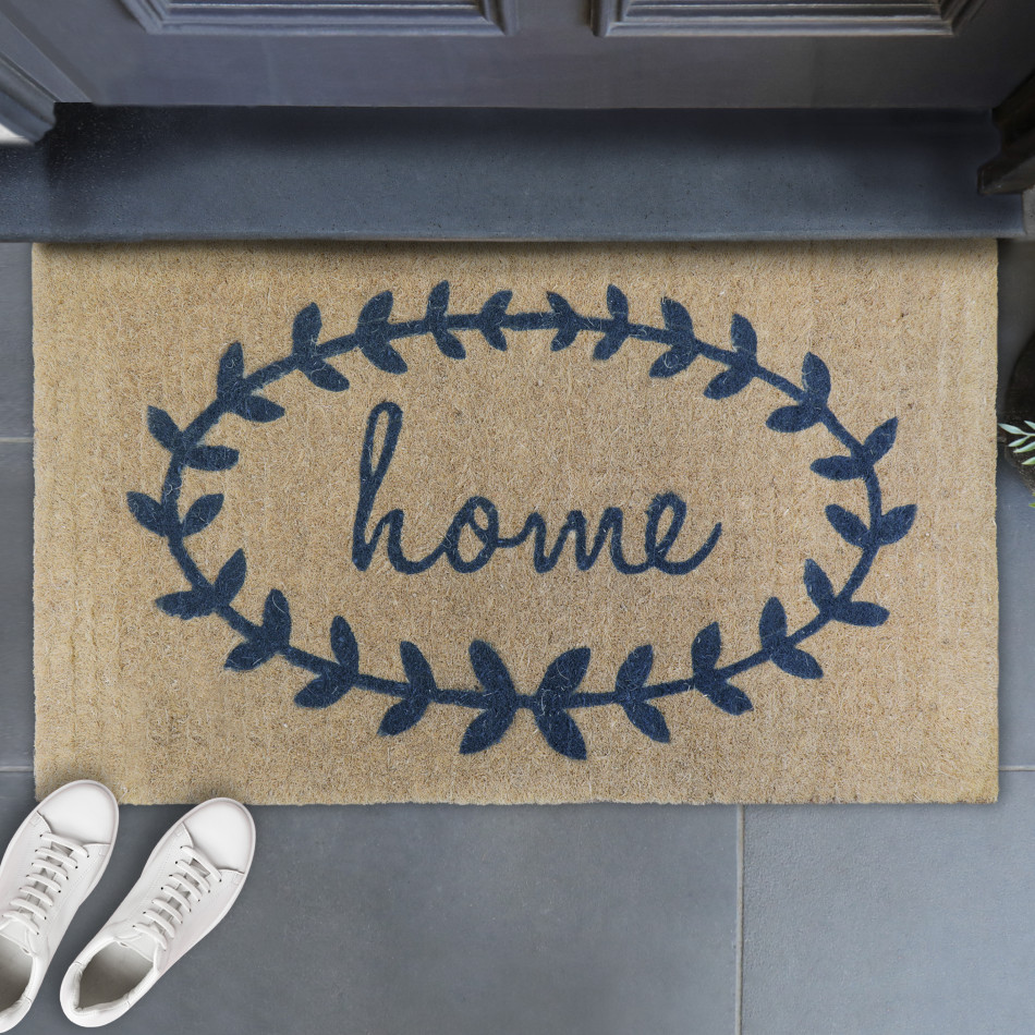 Home Wreath coir doormat with steel-grey script and laurel motif at a sheltered entrance