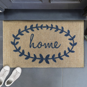Home Wreath coir doormat with steel-grey script and laurel motif at a sheltered entrance