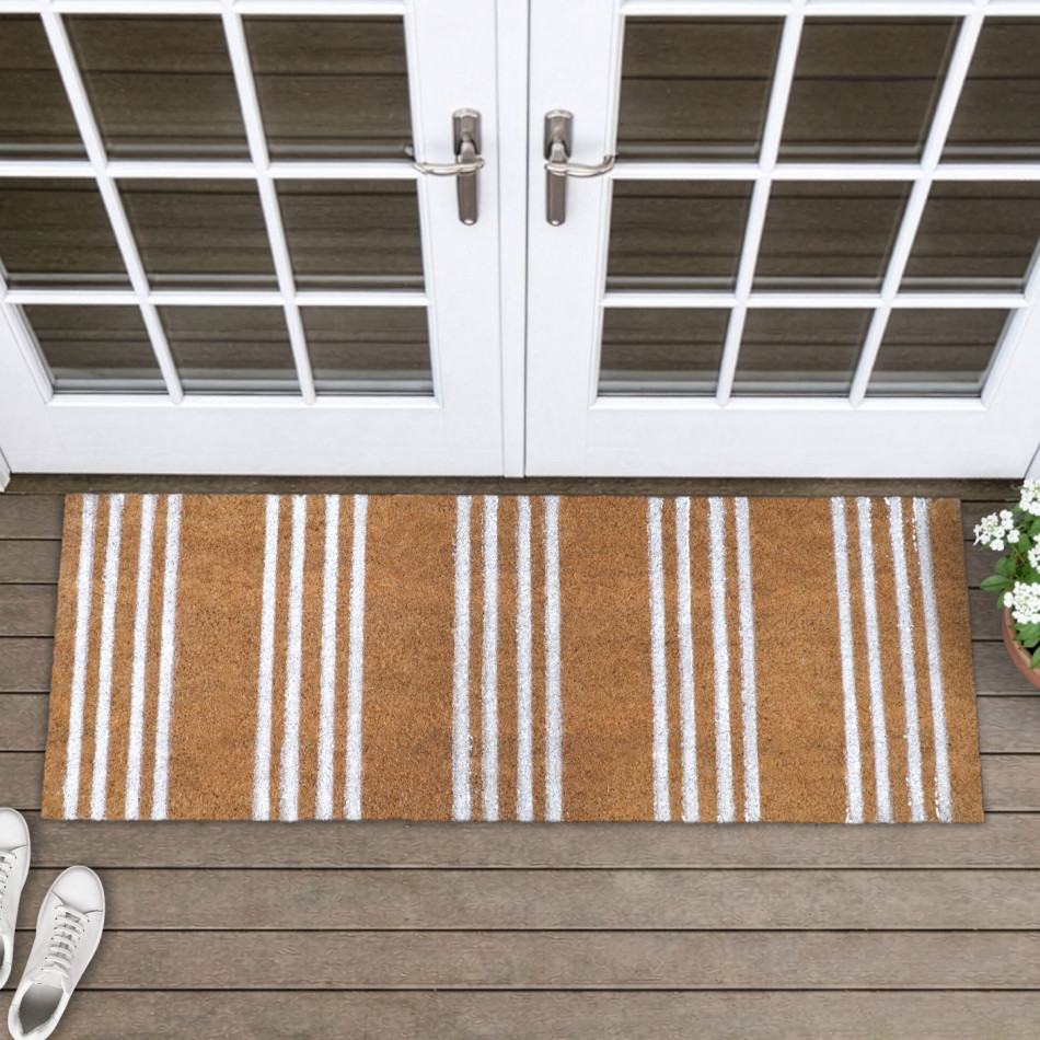 Long natural coir doormat with white ticking stripes on timber boards in front of white French doors