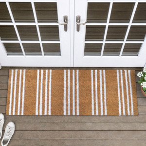 Long natural coir doormat with white ticking stripes on timber boards in front of white French doors