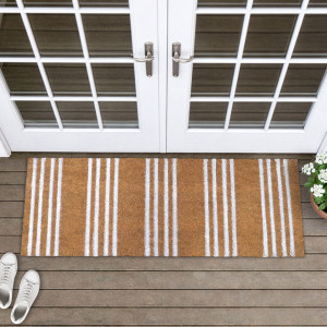 Malleson white stripe doormat at French doors, with white sneakers and potted white flowers nearby