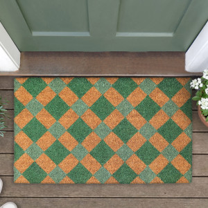 Close-up of a green and natural diamond-patterned coir doormat beside a green door on timber boards
