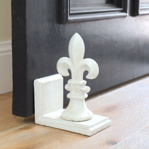 White Fleur de Lys Doorstop, a functional accent designed to hold a door in place