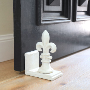 White Fleur de Lys Doorstop, a decorative floor accent made to keep a door securely positioned
