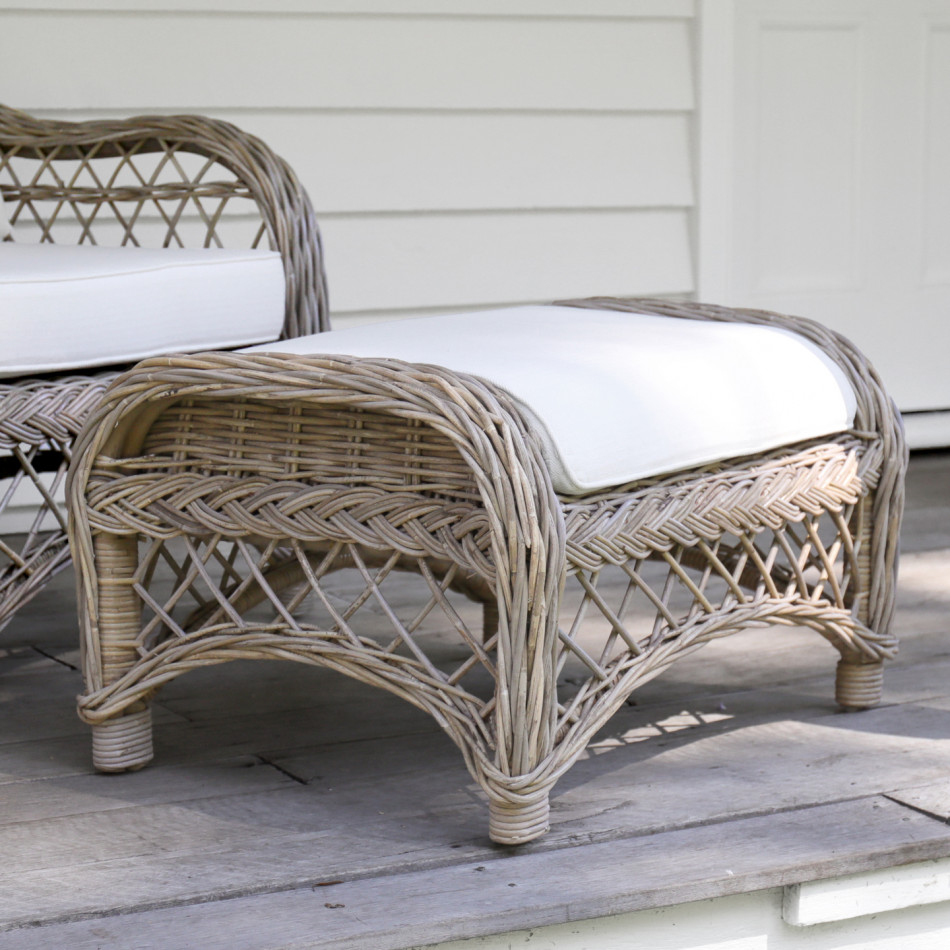 Camden antique grey rattan footstool with cream cushion in a covered porch setting