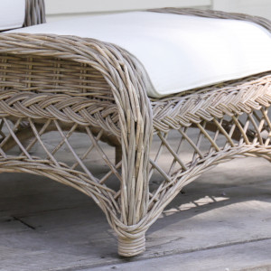 Close view of the Camden footstool’s braided edging, curved frame and open lattice weave