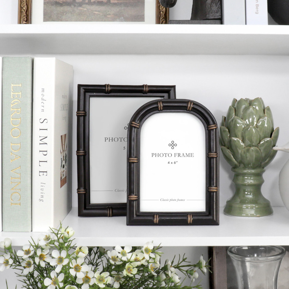 Arched black Remy photo frame styled with a coordinating rectangular frame, books and green ceramic décor
