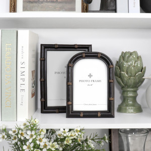 Arched black Remy photo frame styled with a coordinating rectangular frame, books and green ceramic décor