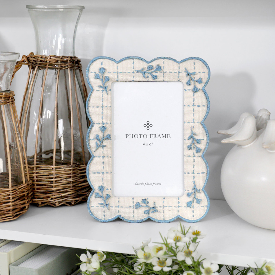 Blue and cream scalloped floral 4x6 photo frame styled on a white shelf with wicker and ceramic décor.