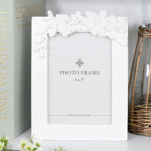 White 5x7 photo frame with raised dahlia flowers and sculpted leaves decorating the top.