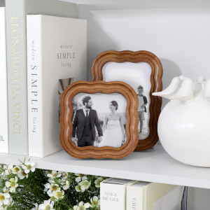 Ralston Curve 4x4 and 4x6 photo frames styled with books and white ceramic décor on a shelf.