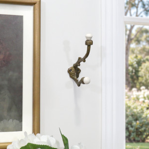 Cranbrook double wall hook displayed near a window and white flowers