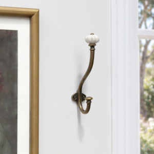 Kenton antique gold wall hook mounted beside a framed artwork