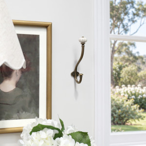 Kenton wall hook styled beside gold-framed artwork and white flowers