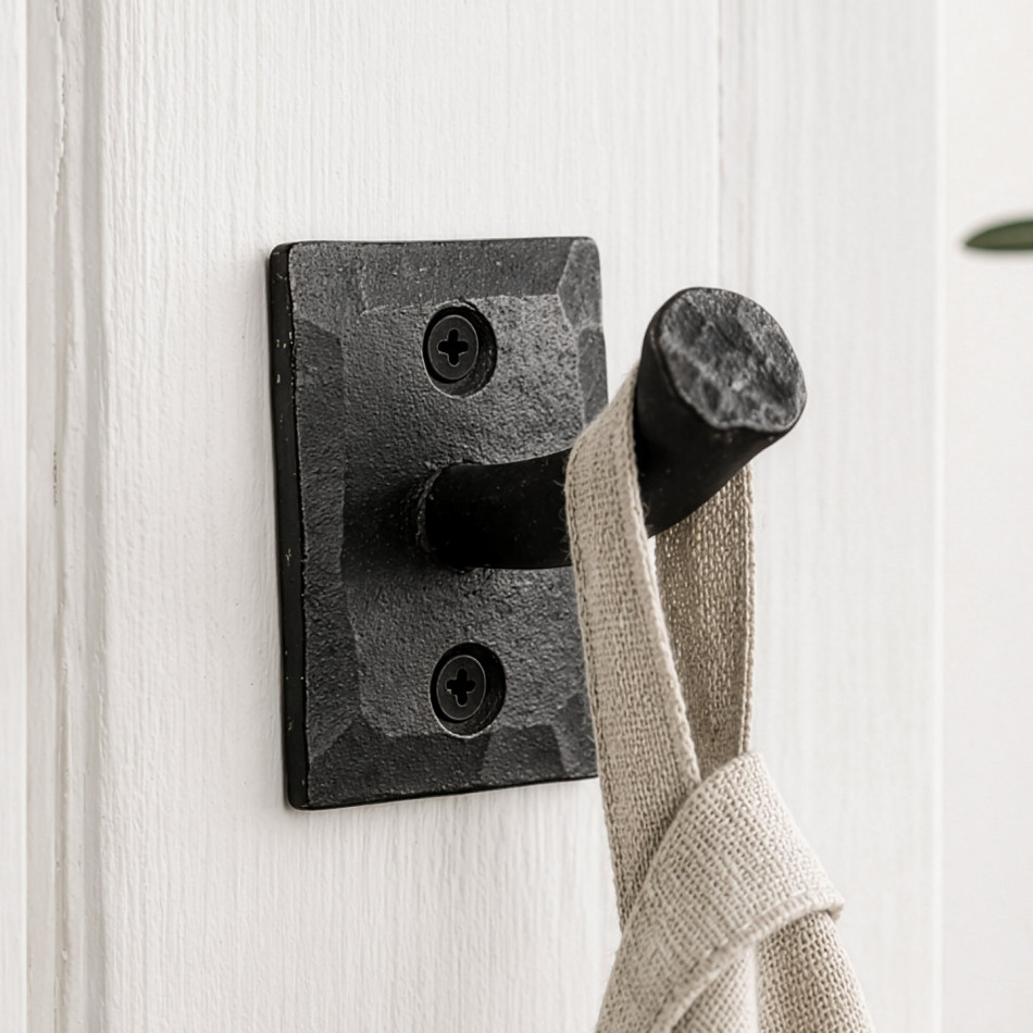 Black Forge iron nail wall hook mounted on white panelling with a natural linen towel