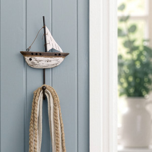 Rustic yacht wall hook displayed on blue panelling beside a bright doorway
