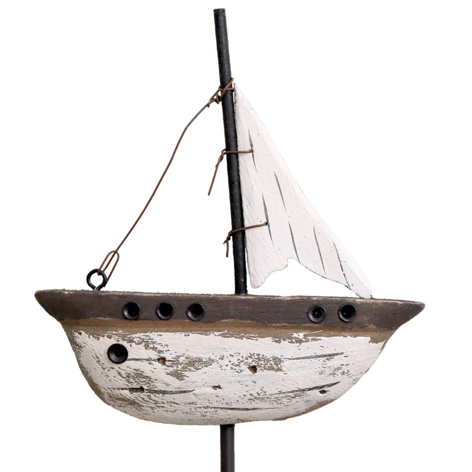 Close-up of the distressed reclaimed wood yacht with white sail, dark mast and porthole details