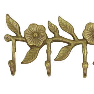 Close-up of the sculpted flowers and veined leaves on the gold metal hook rack