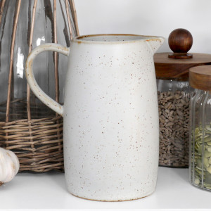 Speckled off-white ceramic milk jug styled beside glass storage jars