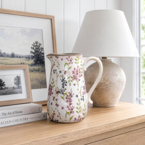 Rosewood floral jug displayed on a timber console with framed prints and a neutral ceramic lamp