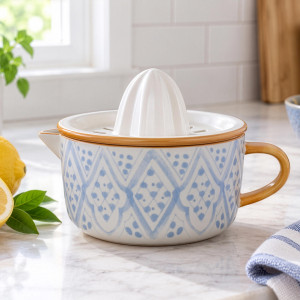 Blue patterned ceramic citrus juicer styled beside fresh lemons and a striped tea towel
