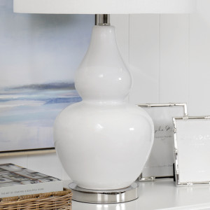 Side view of the Paloma lamp’s curved white glass base and drum shade