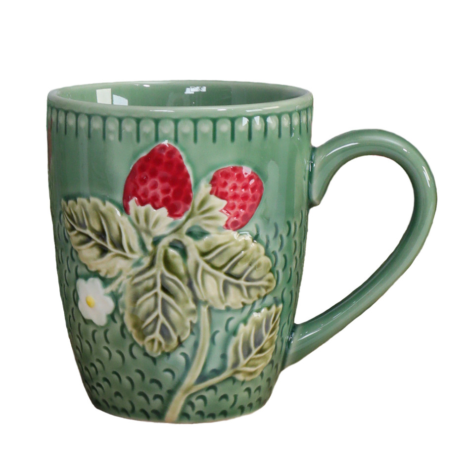 Green ceramic mug with raised red strawberries, leaves and white flowers on a white background