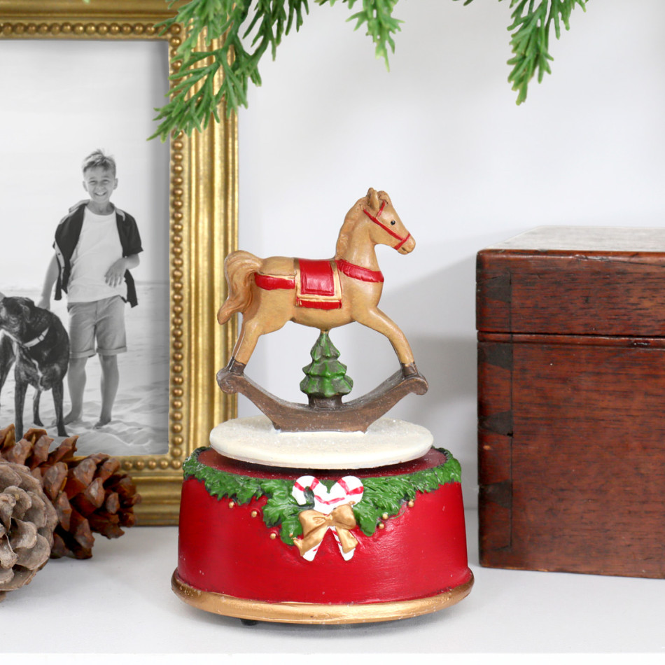 Merry & Bright music box on a white shelf beside a gold photo frame, pinecones and a wooden box