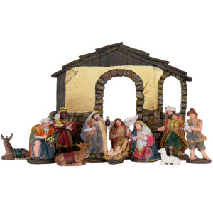 Traditional resin Nativity figures arranged inside a rustic stable