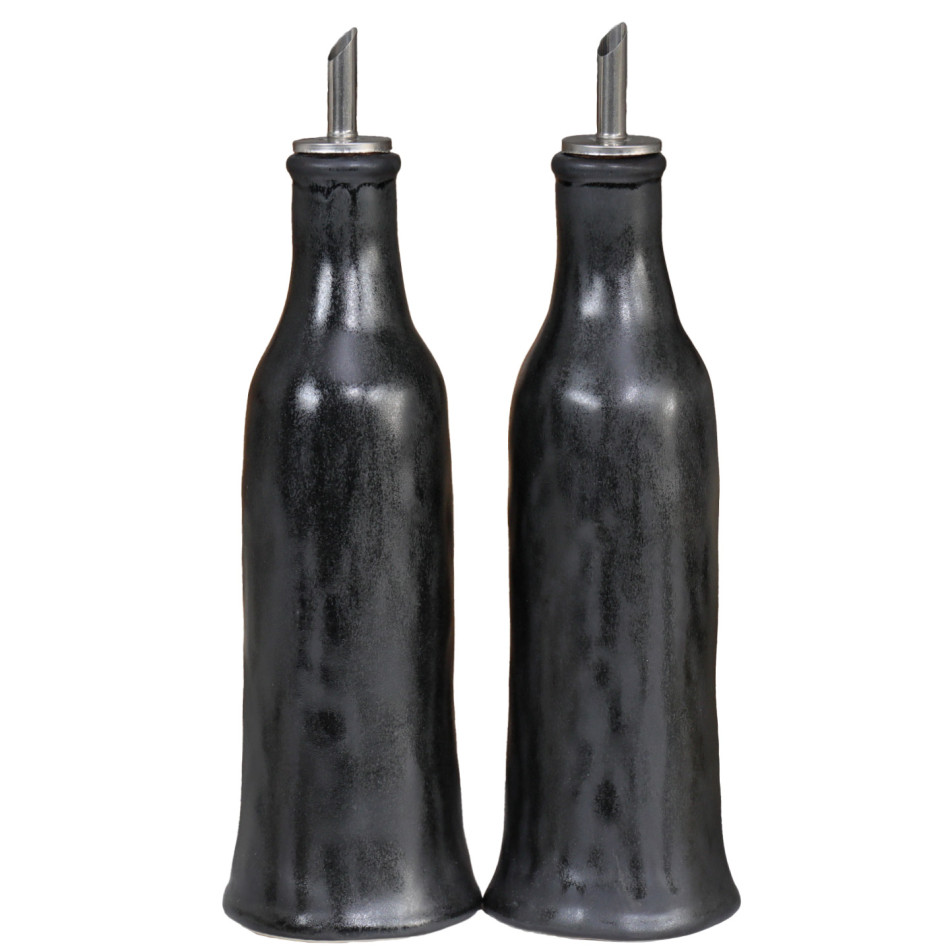 Two tall black reactive-glaze oil and vinegar bottles with metal pourers on a white background.