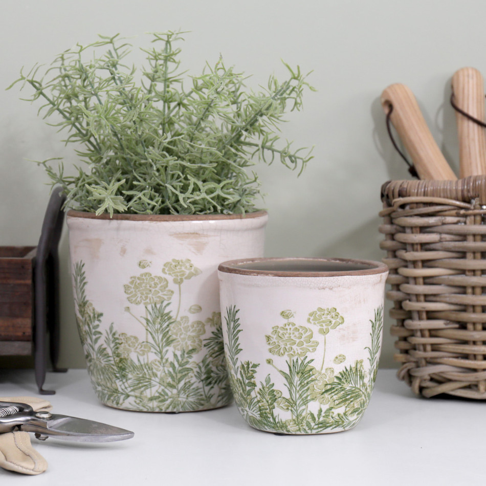 Small Glendale rounded pot in front of the larger pot with foliage, beside a woven tool basket and secateurs