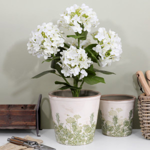 Large Glendale plant pot with white hydrangeas beside a smaller matching pot, gardening tools and a woven basket