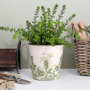 Small Glendale plant pot with green foliage beside a woven tool basket, wooden caddy and gardening gloves