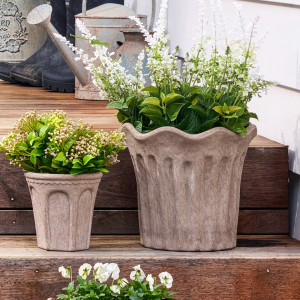 Large Tivoli plant pot with white flowers beside a smaller Varenna Arch planter