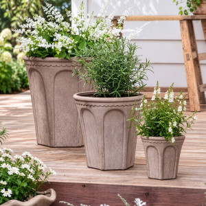 Three Varenna arch plant pots in graduated sizes arranged with greenery and white flowers