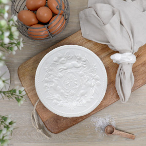White glazed plate with embossed flowers and bunnies and decorative edging