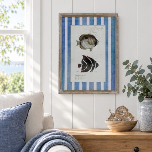 Mariner Fish II framed print above a timber cabinet beside a cream armchair with a blue cushion