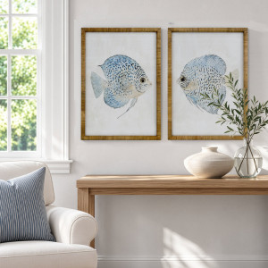 Coral Cove Fish I and II prints in rattan frames above a timber console with vases and greenery