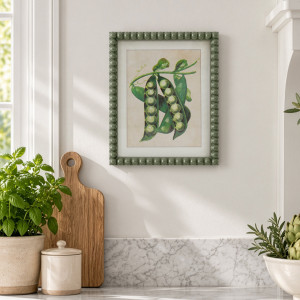 Cottage Garden Green Peas print above a kitchen bench with potted herbs, a timber board and cream canister