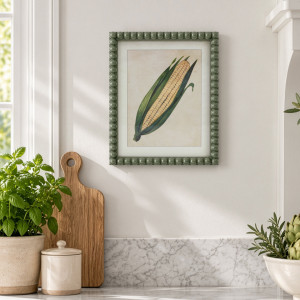 Cottage Garden Sweetcorn print above a kitchen bench with potted herbs, a timber chopping board and cream canister