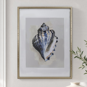 Arcadia Turban shell print in blue and white with a champagne gold frame, styled beside leafy stems