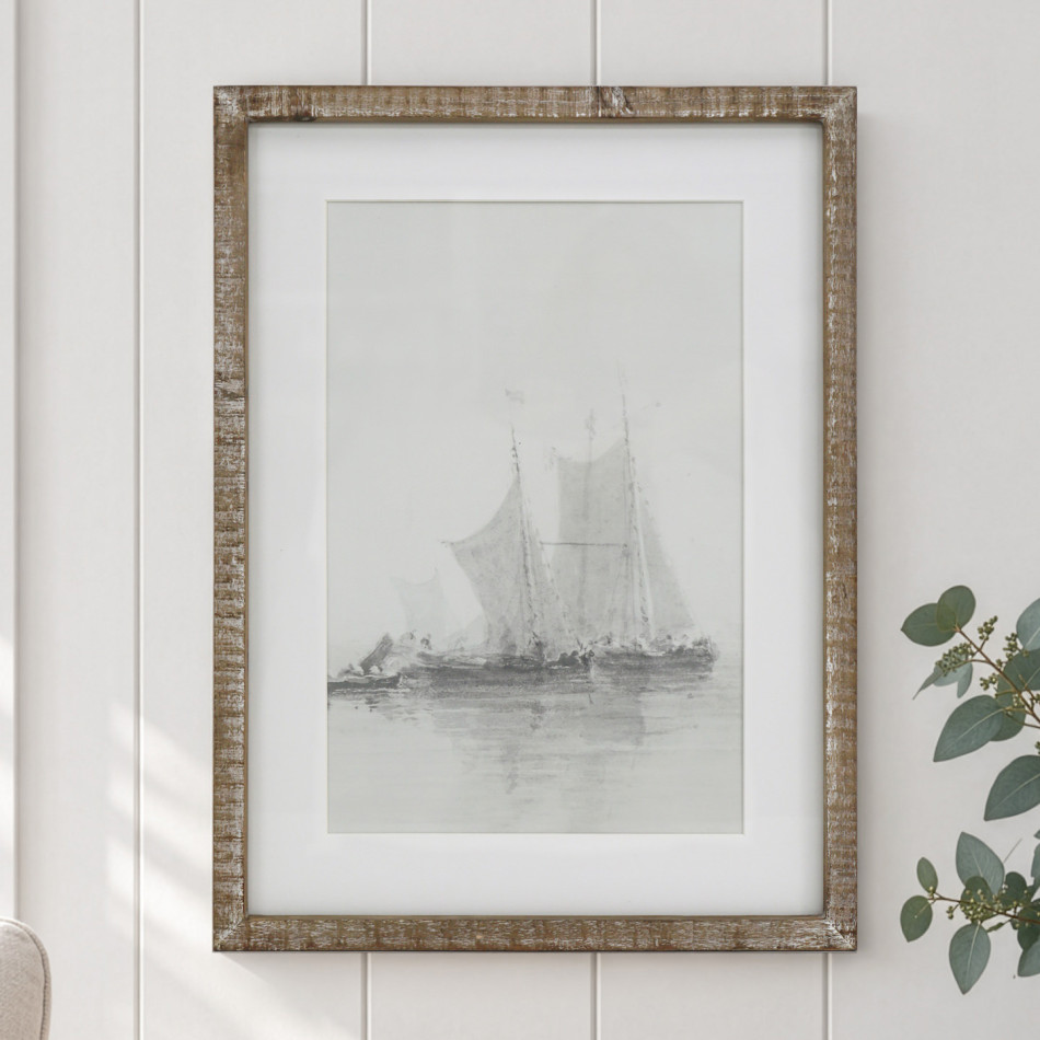 Falmouth Harbour II sailing boat print in a rustic wood frame on a white panelled wall beside eucalyptus