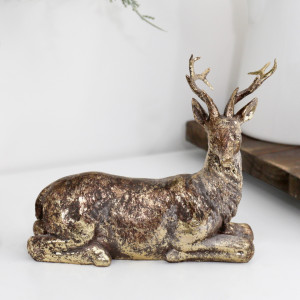 Close-up of resting reindeer with its head on the right, showing textured fur and coppery brown over gold
