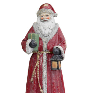 Close-up of Father Christmas showing his painted face, textured beard, green gift, lantern and distressed red coat