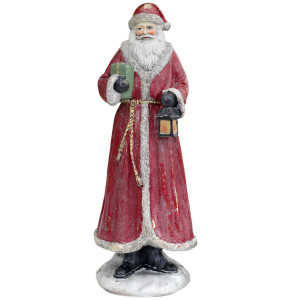 Full view of resin Father Christmas with a red coat, lantern, green gift and pale base against a white background