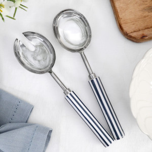 Blue and white striped salad servers with polished stainless steel heads styled on a white tablecloth