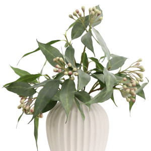 Close-up of green artificial seeded eucalyptus arranged in a white ribbed vase