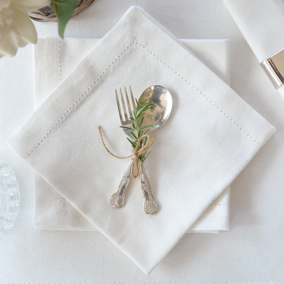 White cotton tablecloth with additional white table setting napery