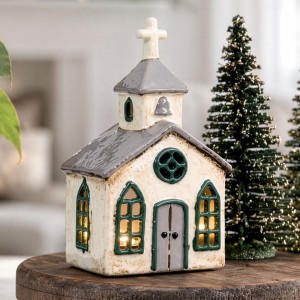 Close-up of ceramic Christmas chapel with a grey roof, green window surrounds and a cross-topped tower