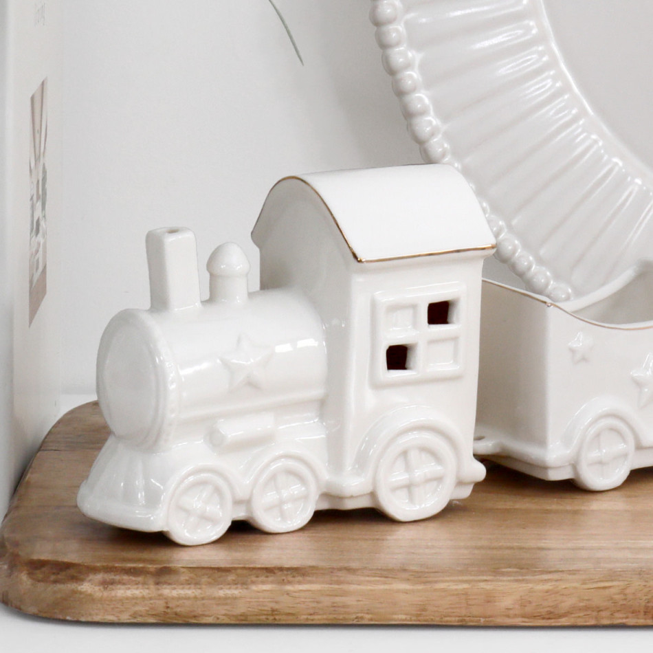 Close-up of the North Pole ceramic locomotive showing raised stars, moulded wheels, cabin windows and gold roof edging.